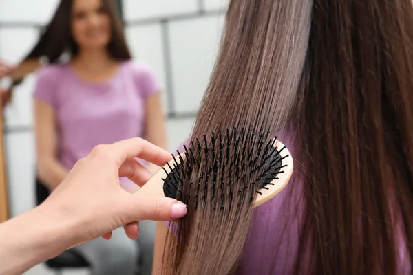 Mulher pentear o cabelo do amigo com escova de almofada dentro de casa, close-up — Fotografia de Stock