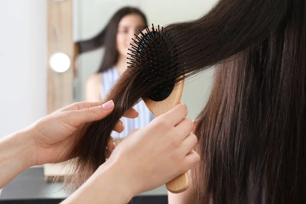 Mulher pentear o cabelo do amigo com escova de almofada dentro de casa, close-up — Fotografia de Stock
