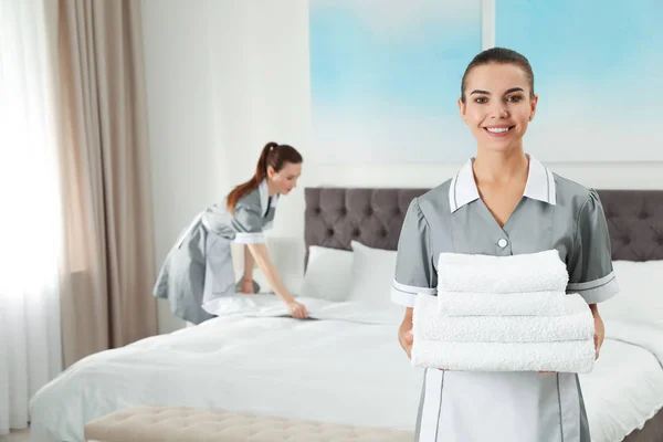 Chambermaid s čerstvým ručníkem v hotelovém pokoji. Místo pro text — Stock fotografie