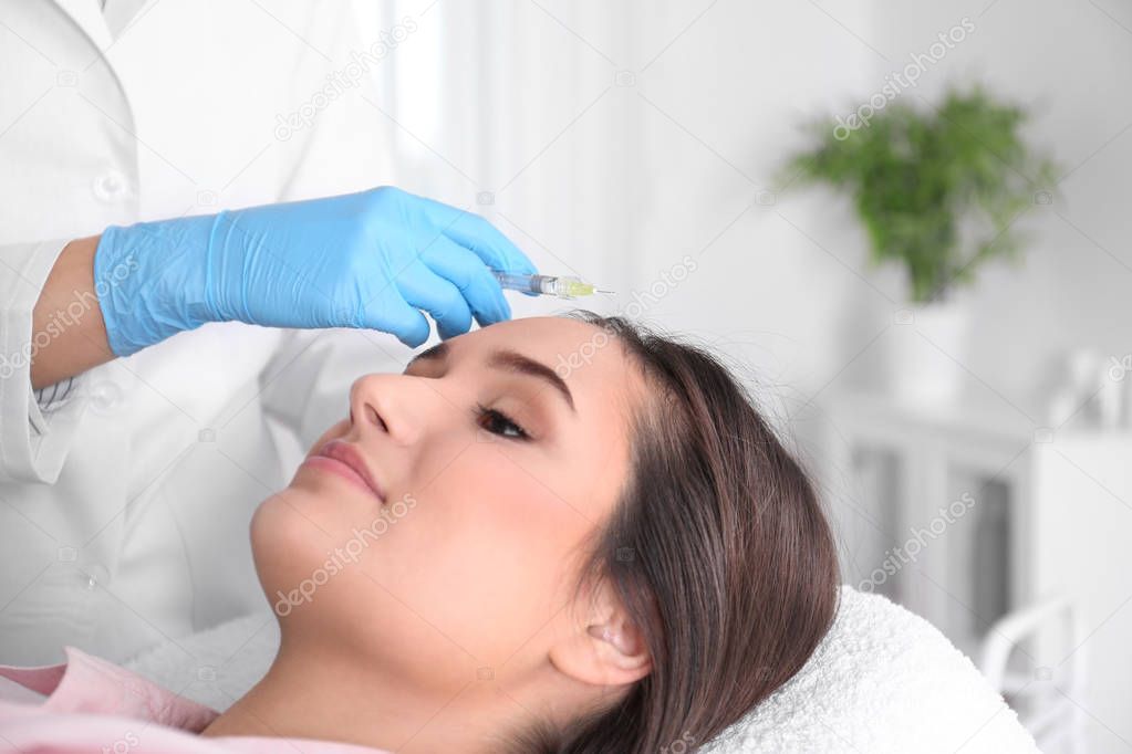 Young woman with hair loss problem receiving injection in salon