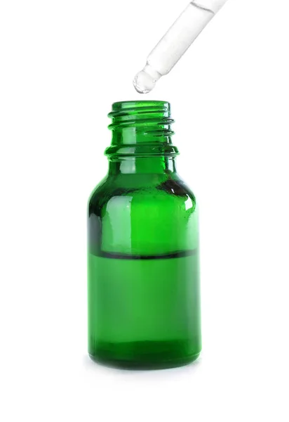 Викидання трав'яної ефірної олії в пляшку ізольовано на білому — стокове фото