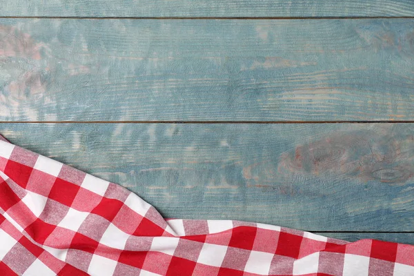 Koc piknikowy w kratkę na drewnianym tle, widok z góry. Miejsce na tekst — Zdjęcie stockowe