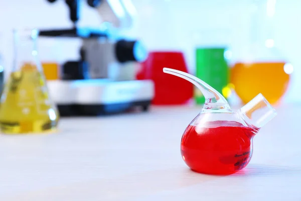 Kolba retorowa z próbką na stole w laboratorium chemii, miejsce na tekst — Zdjęcie stockowe