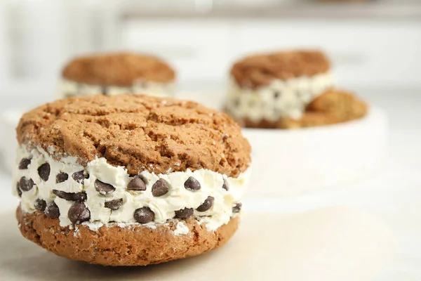 Sweet delicious ice cream cookie sandwich with chocolate chips on table, closeup. Space for text