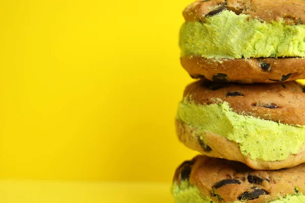 Sweet delicious ice cream cookie sandwiches on color background, closeup. Space for text