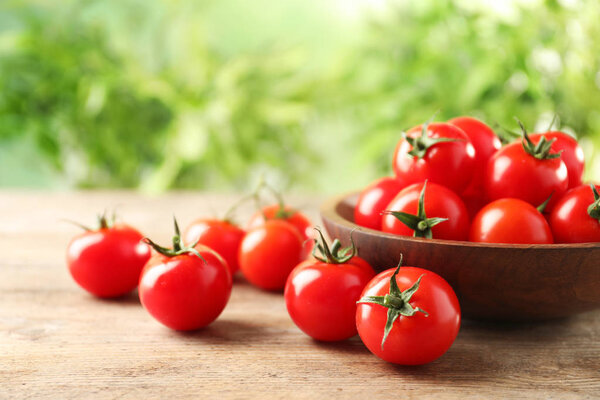 Bowl of fresh cherry tomatoes on wooden table
