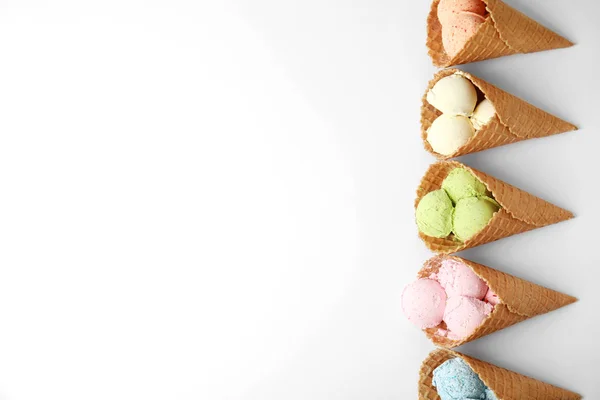 Komposition mit leckerem Eis in Waffelkegeln auf weißem Hintergrund, Ansicht von oben — Stockfoto