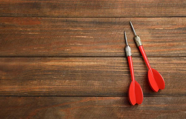 Flechas de dardo sobre fondo de madera, planas. Espacio para texto — Foto de Stock