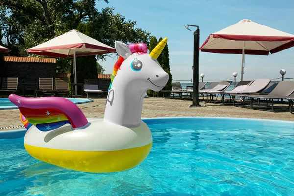 Anillo de unicornio inflable divertido flotando en la piscina en el día soleado, al aire libre. Espacio para texto — Foto de Stock