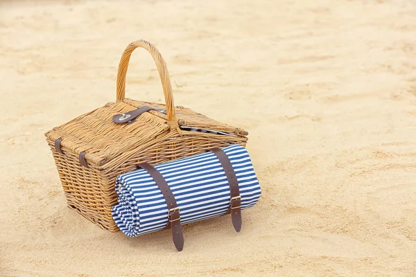 Panier pique-nique en osier avec couverture sur sable, espace pour le texte — Photo