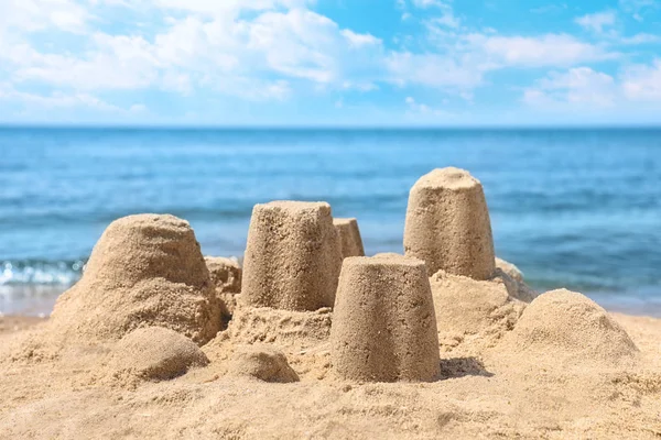 Pequenas figuras de areia na praia perto do mar — Fotografia de Stock
