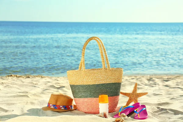 Composition avec accessoires de plage élégants sur sable près de la mer — Photo