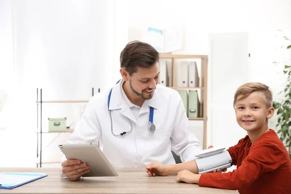 Médico revisando el pulso del niño pequeño con dispositivo médico en el hospital — Foto de Stock