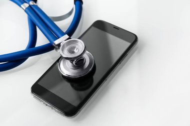 Akıllı telefon ve ışık tablosunda stetoskop, metin için alan ile yakın çekim. Onarım hizmeti