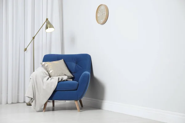 时尚的扶手椅，带枕头和格子，靠近白色墙壁，适合文字。室内设计 — 图库照片