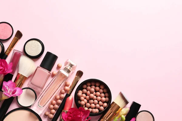 Diferentes productos de maquillaje con flores sobre fondo de color. Espacio para texto — Foto de Stock