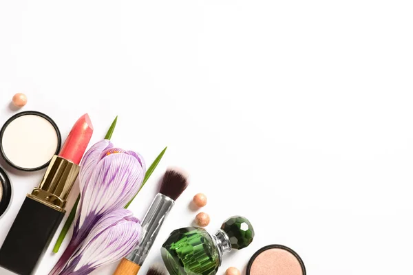 Διαφορετικά προϊόντα μακιγιάζ και λουλούδια σε λευκό φόντο, κορυφή θέα — Φωτογραφία Αρχείου