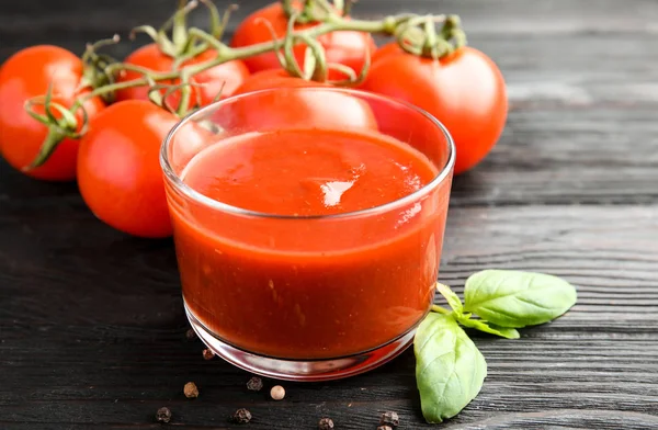 Verre de sauce tomate au basilic sur table en bois, gros plan — Photo