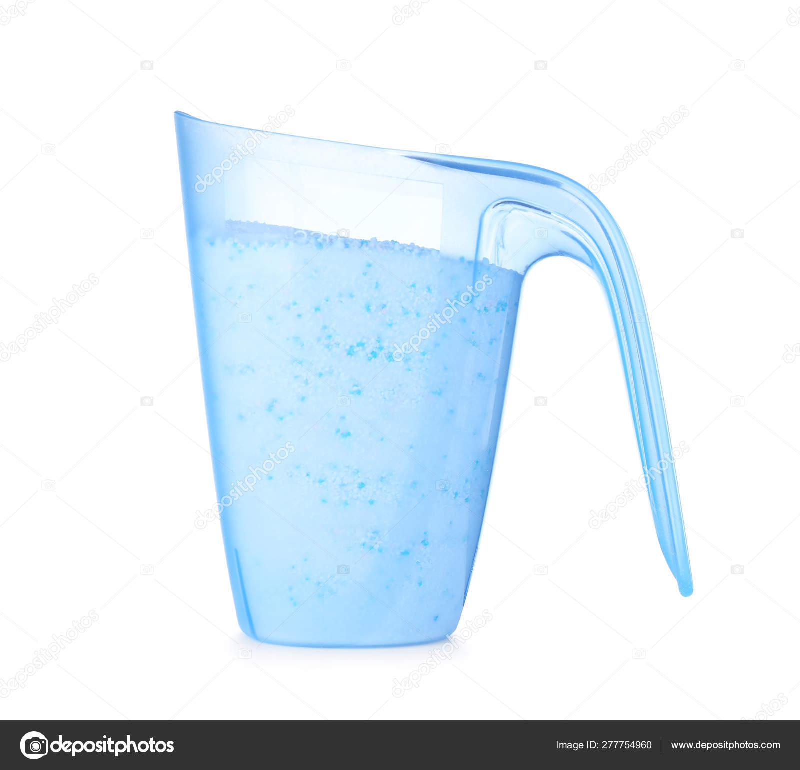 Laundry detergent in plastic measuring cup on white background