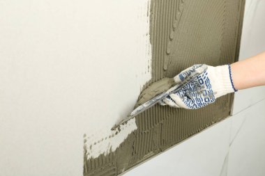 İşçi, spatula, metin alanı ile duvara beton yayma closeup. Döşeme kurulumu