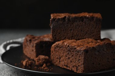 Siyah arka plan, metin için boşluk karşı gri masada taze brownie ile Plaka. Lezzetli çikolatalı pasta