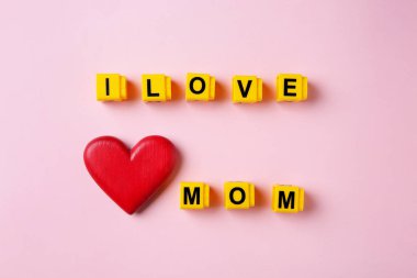 Phrase I Love Mom plastik harfler ve renkli arka plan ahşap kalp yapılmış, üst görünümü