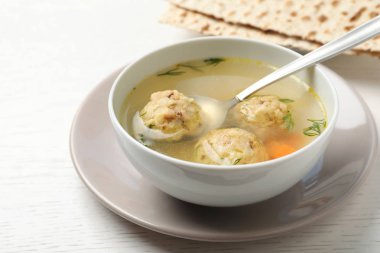 Beyaz ahşap masa üzerinde Yahudi matzoh topları çorba Kase