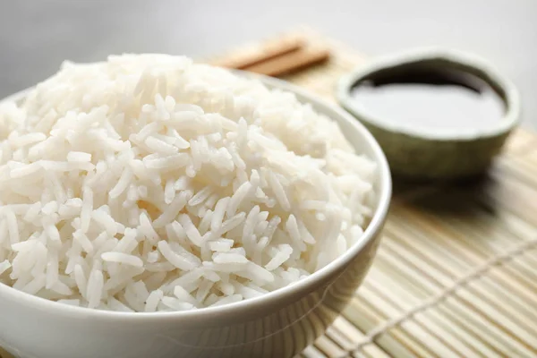 Tigela de saboroso arroz cozido servido na mesa, close-up — Fotografia de Stock