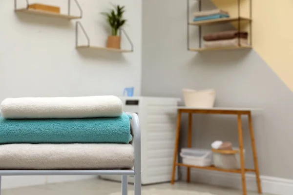 Montón de toallas limpias en la mesa en el lavadero. Espacio para texto —  Fotos de Stock