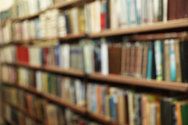 Vista borrosa de los estantes con libros en la biblioteca —  Fotos de Stock