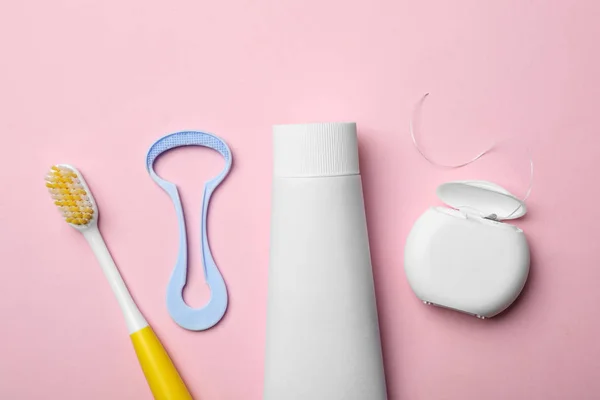 Composição de leigos planos com limpador de língua e produtos de cuidados de dentes no fundo de cor — Fotografia de Stock