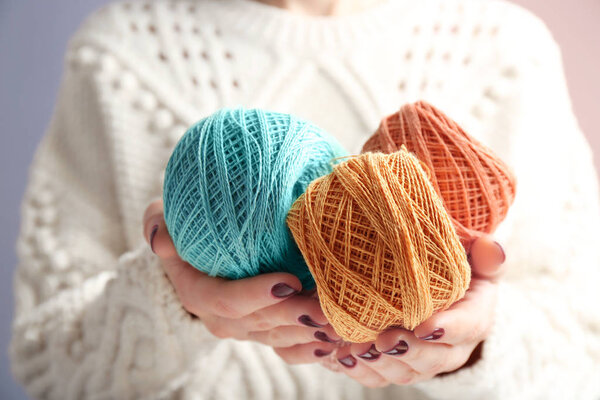 Woman holding clews of knitting threads, closeup