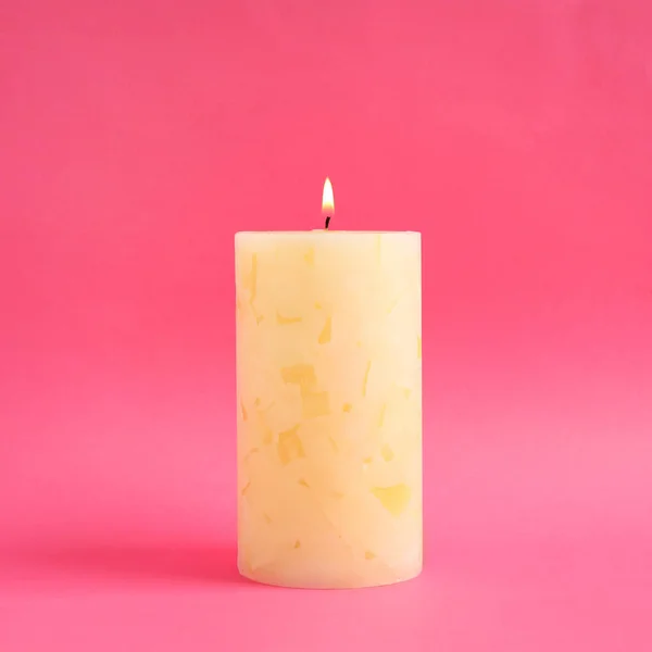 Alight scented wax candle on color background