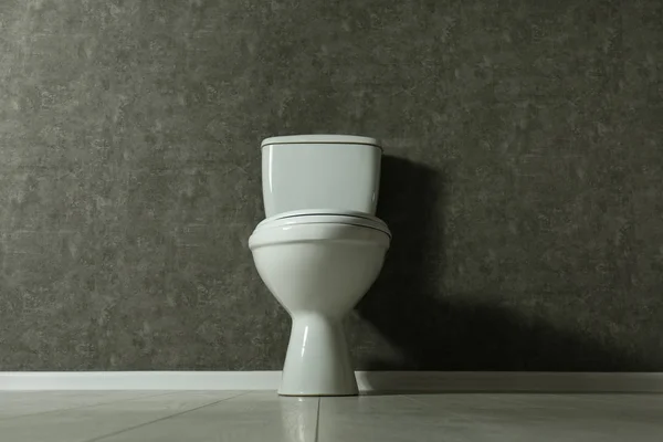 Neue Toilettenschüssel in der Nähe grauer Wände — Stockfoto