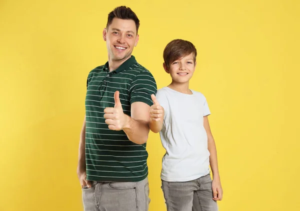 Portrait of dad and his son on color background — Stock Photo, Image