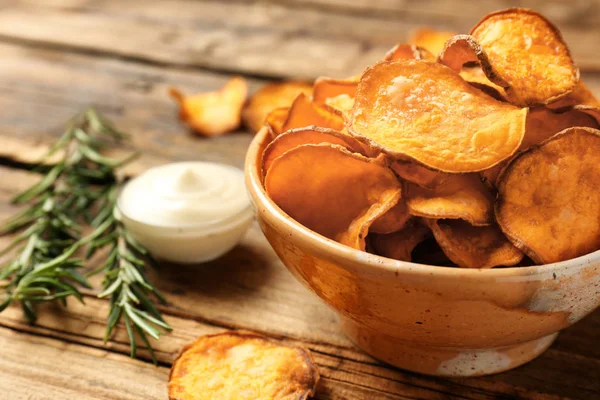 Leckere Süßkartoffelchips in Schüssel, Rosmarin und Soße auf dem Tisch. Raum für Text — Stockfoto