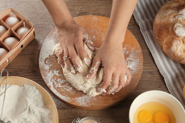 Женщина-пекарь готовит тесто для хлеба за кухонным столом, вид сверху — стоковое фото
