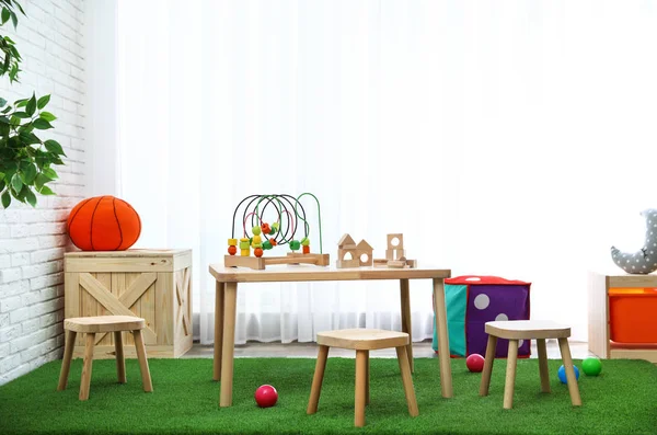 Interior elegante da sala de jogos com brinquedos e mobiliário de madeira moderna — Fotografia de Stock