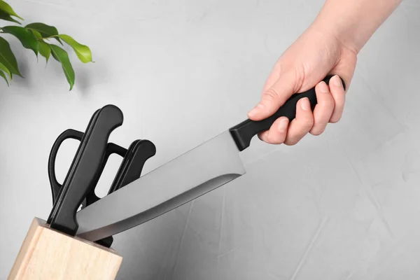 Mujer sosteniendo cuchillo de chef sobre fondo gris, primer plano. Platos limpios —  Fotos de Stock