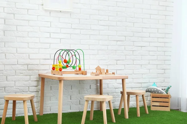 Elegante sala giochi interna con giocattoli e mobili in legno moderno — Foto Stock