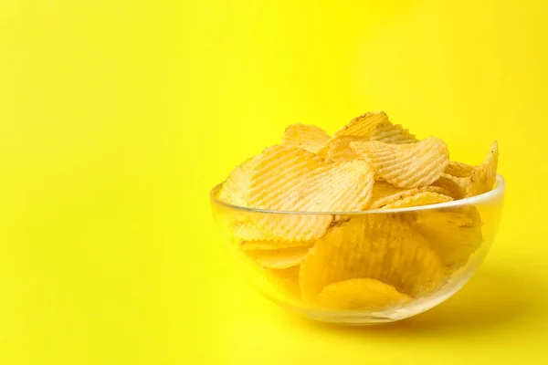 Heerlijke knapperige chips in kom op kleur achtergrond, ruimte voor tekst — Stockfoto