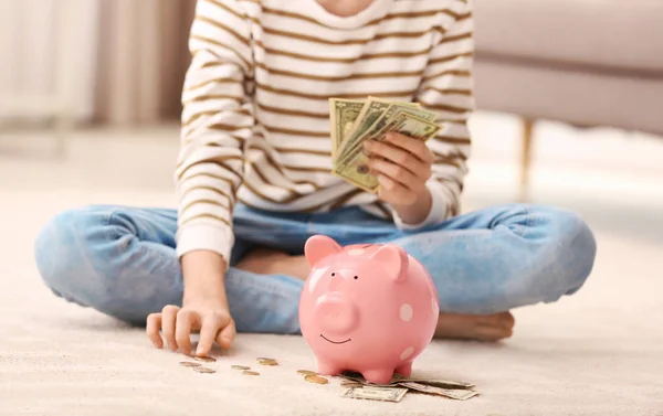 Tiener meisje met Piggy Bank en geld thuis, close-up — Stockfoto
