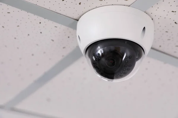 Câmera de CCTV de segurança moderna no teto no escritório, espaço para texto. Sistema de protecção — Fotografia de Stock
