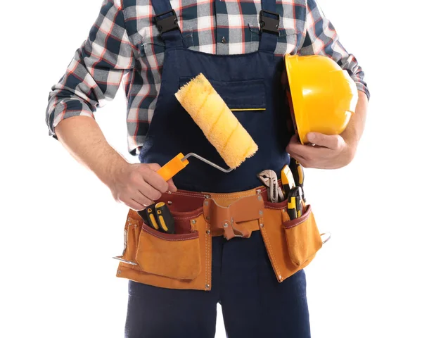 Construction worker with hard hat, paint roller and tool belt on white background, closeup — Stock Photo, Image