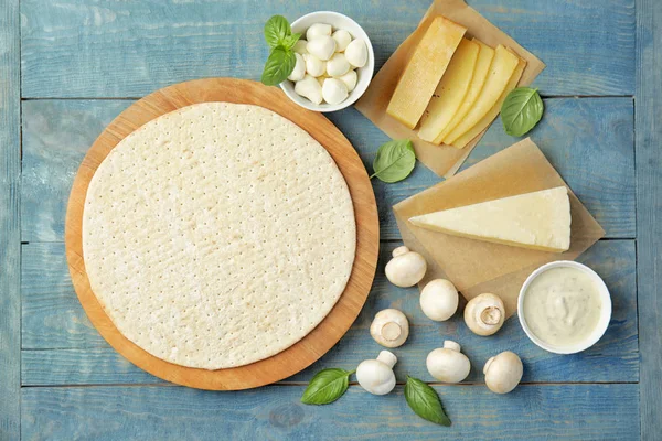 Composizione posata piatta con base e ingredienti per pizza su tavola di legno — Foto Stock