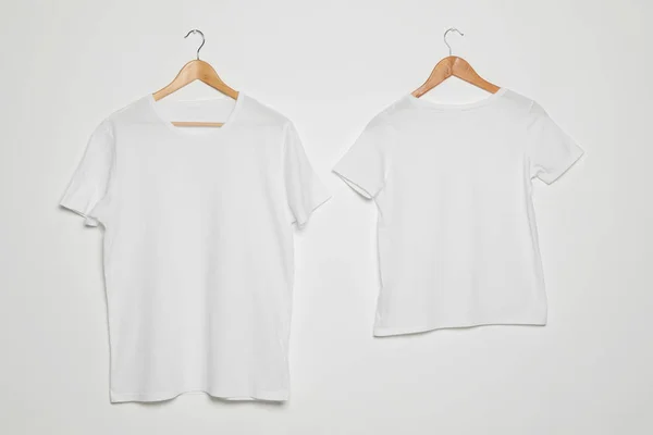 Hangers met blanco t-shirts op witte achtergrond. Mock up voorontwerp — Stockfoto