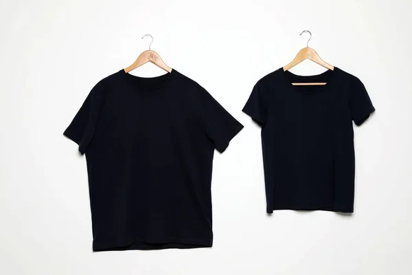 Hangers met blanco t-shirts op witte achtergrond. Mock up voorontwerp — Stockfoto