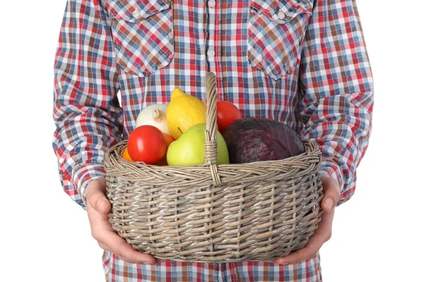 Hombre sosteniendo cesta llena de verduras frescas y frutas sobre fondo blanco, primer plano — Foto de Stock