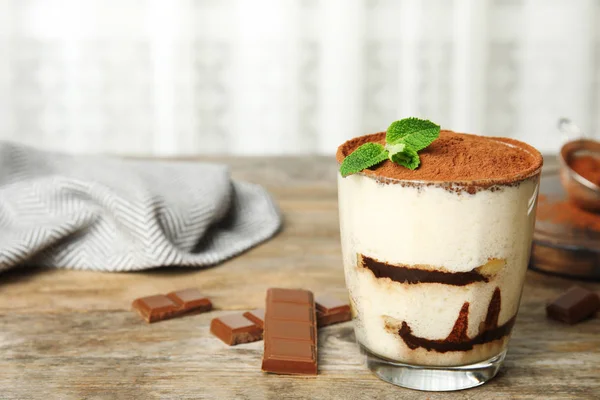 Glas Tiramisu-Kuchen und Schokolade auf Holztisch, Platz für Text — Stockfoto