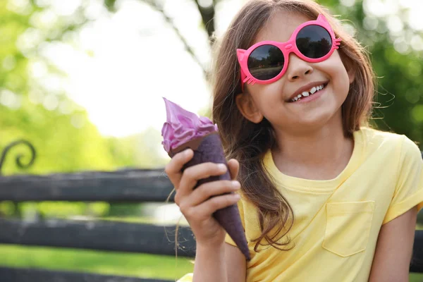 公園のベンチでおいしいアイスクリームを持つかわいい女の子、テキストのためのスペース — ストック写真